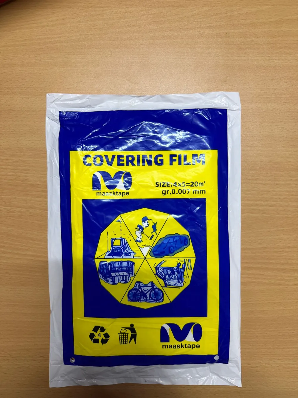 Maasktape Covering Film retail pack — a folded blue-and-yellow LDPE film pack marked “SIZE:4x5=20m²”, “gr.0.007mm” and recycling code 4, with pictograms of a covered car, furniture, machinery, motorbike and appliances.