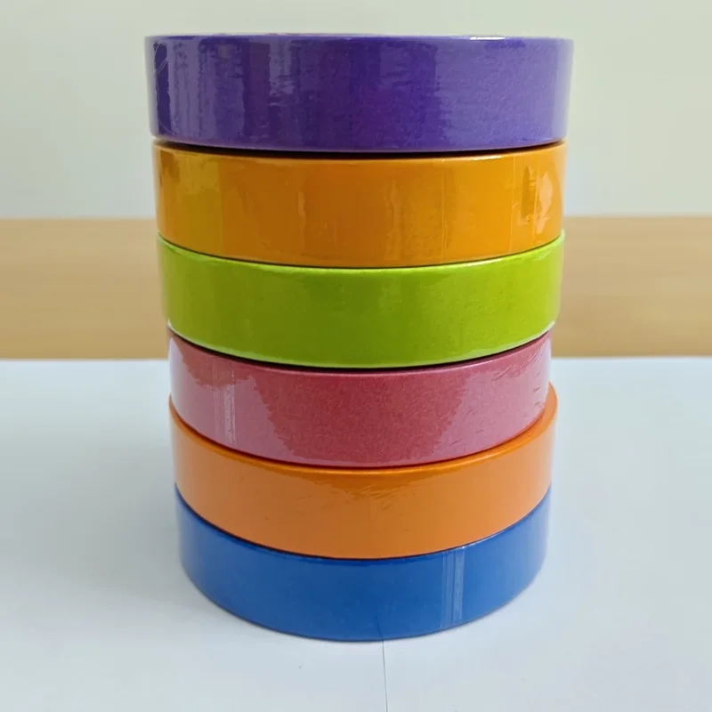 A stack of six rolls of Maasktape automotive masking tape — violet, yellow, green, pink, orange and blue