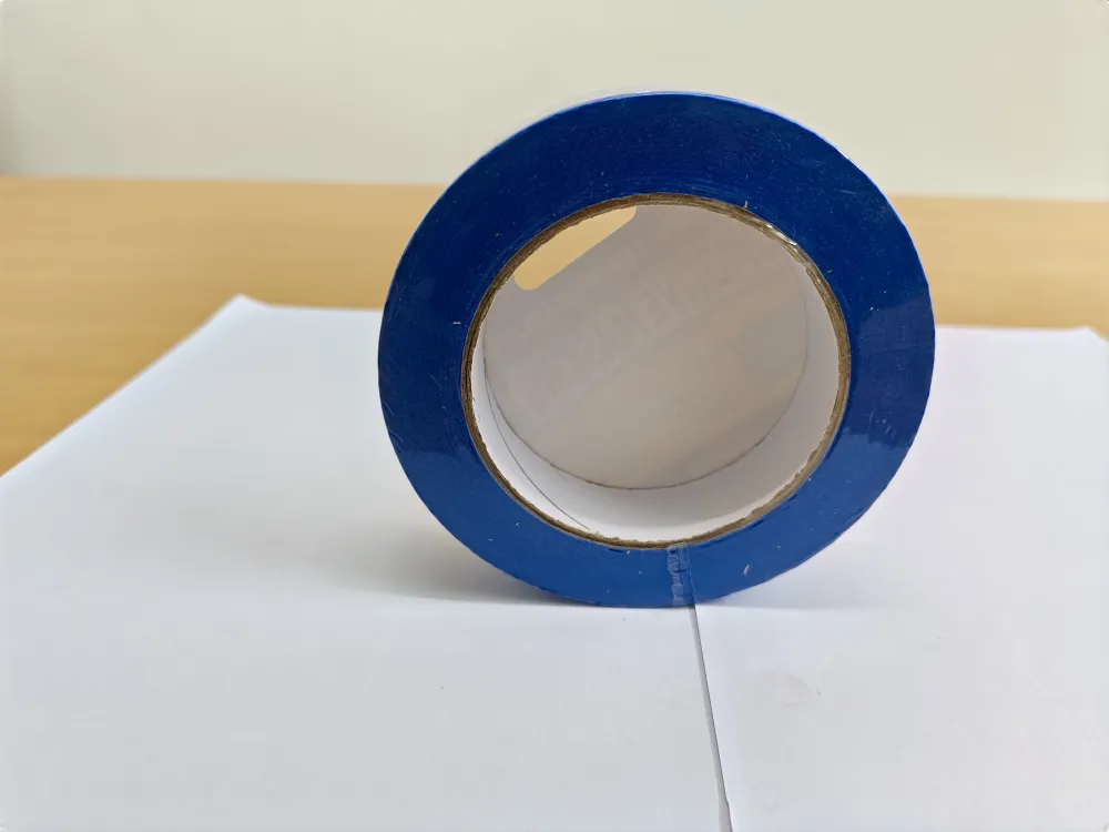 Roll of Maasktape Blue masking tape, 24 mm by 50 m, side profile showing a clean, dense wound edge — no feathering.